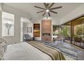 A spacious main bedroom with a fireplace, sitting area, and a large window view at 10638 E Honey Mesquite Dr, Scottsdale, AZ 85262