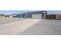 Single-story home with a long driveway, gravel front yard, solar panels, and an attached garage at 11012 E Elton Ave, Mesa, AZ 85208