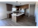 Bright kitchen features an island, wood cabinets, granite countertops, stainless steel appliances, and tile floors at 11650 N Abel Pl, Florence, AZ 85132