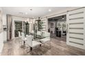 Modern dining room with a glass table, white chairs, a stylish light fixture, and a sliding barn door at 11822 S Coconino St, Phoenix, AZ 85044
