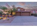 Charming two-story home with a three car garage and desert landscaping under a colorful sunset sky at 14056 E Desert Cove Ave, Scottsdale, AZ 85259