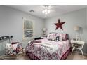 Cozy bedroom with patriotic decor, a ceiling fan, and a window providing natural light at 14112 W Larkspur Dr, Surprise, AZ 85379
