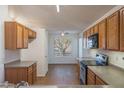 Traditional kitchen features oak cabinets, laminate countertops, and wood-look vinyl flooring at 15701 N Bonow Dr, Surprise, AZ 85374