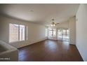 Bright living room with vaulted ceilings, fan, and sliding glass doors at 15701 N Bonow Dr, Surprise, AZ 85374