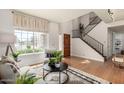 Bright and airy living room with stairs, wooden floors, and a view to the outdoors at 16823 S 24Th Pl, Phoenix, AZ 85048