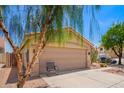 View of the home's terracotta tile roof and two car garage with low maintenance desert landscaping at 2015 E Glenhaven Dr, Phoenix, AZ 85048