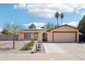Inviting home featuring a desert landscape, palm trees, and solar panels, offering both curb appeal and sustainability at 207 E Strahan Dr, Tempe, AZ 85283