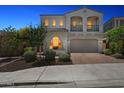 Elegant two-story home with arched windows, balcony, and a well-manicured front yard at twilight at 22306 N 34Th Pl, Phoenix, AZ 85050