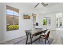 Home office with natural light, a rustic wood desk, mounted TV, and views of the lush outdoors at 22306 N 34Th Pl, Phoenix, AZ 85050