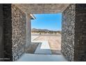 Inviting stone entryway frames a bright view of the desert landscape, welcoming guests to the home at 30639 N Dorado Ct, Queen Creek, AZ 85144