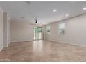 Open-concept living room featuring neutral walls, tile flooring, recessed lighting, and a sliding glass door to the outside at 3507 E Alfalfa Dr, Gilbert, AZ 85298