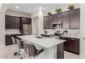 Spacious kitchen featuring an island with bar seating and dark cabinets at 3852 E Bartlett Way, Chandler, AZ 85249