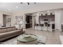 Open-concept living room and kitchen with a comfortable couch and modern bar stools at 3852 E Bartlett Way, Chandler, AZ 85249