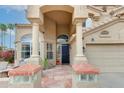 Home entrance featuring tiled walkway, glass-blocked bases, and columns supporting an arched door entrance at 5940 W Robinson Way, Chandler, AZ 85226