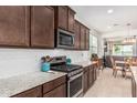 Modern kitchen with granite countertops, stainless steel appliances, and an open layout to the living area at 607 W Tenia Trl, San Tan Valley, AZ 85140