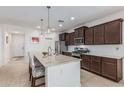 An updated kitchen features a granite island, stainless steel appliances, and tile flooring at 607 W Tenia Trl, San Tan Valley, AZ 85140
