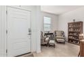 Inviting living room features tile flooring, a bright white door, and an elegant seating area with a bookshelf at 607 W Tenia Trl, San Tan Valley, AZ 85140