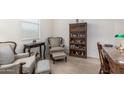 Inviting living room features tile flooring, and an elegant seating area with a bookshelf with glass doors at 607 W Tenia Trl, San Tan Valley, AZ 85140