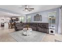 Spacious living room with a comfortable sofa, a ceiling fan, and an open layout leading to the dining area at 607 W Tenia Trl, San Tan Valley, AZ 85140
