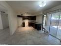 Kitchen featuring tile flooring, dark cabinets, granite countertops and sliding glass door at 6605 N 46Th Ln, Glendale, AZ 85301