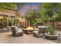 A tranquil patio features a stone fire pit surrounded by comfortable seating at 7117 E Rancho Vista Dr # 1012, Scottsdale, AZ 85251