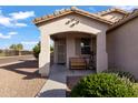 Charming covered front porch with a cozy bench and decorative plants at 7305 W Darrel Rd, Laveen, AZ 85339
