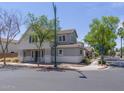 Exterior view of a two-story home with neutral paint, a charming porch, and professional landscaping at 8723 E Kiowa Ave, Mesa, AZ 85209