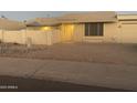 Charming single-story home with neutral toned exterior, a rock yard, and a quaint patio umbrella at 1055 N 86Th Pl, Scottsdale, AZ 85257