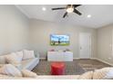 Cozy living room featuring plush sofas, modern ceiling fan, and a wall-mounted television at 1055 N 86Th Pl, Scottsdale, AZ 85257