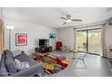 Bright living room with a ceiling fan, unique modern furniture, and sliding doors to the outdoor patio at 1124 E Rose Ln # 17, Phoenix, AZ 85014