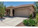 Spacious two-car garage with a concrete driveway and desert landscaping in front at 12417 W Apache St, Avondale, AZ 85323