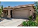Spacious two-car garage with a concrete driveway and desert landscaping in front at 12417 W Apache St, Avondale, AZ 85323