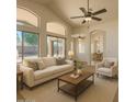 Bright living room with high ceilings, ceiling fan, and sliding glass doors at 17617 W Corrine Dr, Surprise, AZ 85388