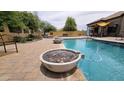 A serene backyard pool with a rock water feature and outdoor lounge area, perfect for relaxation at 1766 N Channing --, Mesa, AZ 85207