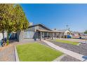 Charming single-story home with a well-manicured front yard featuring artificial turf and a covered porch at 2022 W Aster Dr, Phoenix, AZ 85029