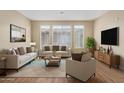 Bright, staged living room with neutral tones, comfortable seating, and ample natural light at 240 W Juniper Ave # 1211, Gilbert, AZ 85233