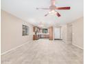 Spacious, bright living room featuring tile floors, a ceiling fan, and an open layout to the kitchen at 3719 W Carson Rd, Phoenix, AZ 85041