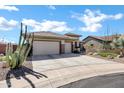 Stylish single-story home with a three-car garage and desert landscaping along the driveway at 41215 N Lytham Ct, Phoenix, AZ 85086