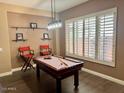 Entertain in this game room featuring a pool table, light fixture and plantation shutters at 41215 N Lytham Ct, Phoenix, AZ 85086
