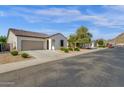 A view of the home's facade showcasing its desert landscaping in a well-maintained community at 4595 W Foldwing Dr, San Tan Valley, AZ 85144