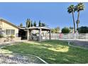 Spacious backyard with grassy area, outdoor kitchen, and palm trees at 4838 W Christine Cir, Glendale, AZ 85308