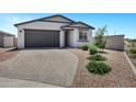 Inviting single-story home with a grey garage, desert landscaping, and a beautiful paver driveway at 6145 S Adelle --, Mesa, AZ 85212