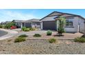 Well-maintained single-story homes, with desert landscaping, grey garages and a welcoming neighborhood street at 6145 S Adelle --, Mesa, AZ 85212