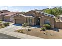 Full frontal view of a home with desert landscaping, two-car garage and neutral stucco siding at 6213 W Gambit Trl, Phoenix, AZ 85083