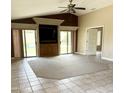 Spacious living room with tile and carpet flooring and sliding door access to the pool at 6436 W Saddlehorn Rd, Phoenix, AZ 85083