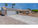 Front exterior showcasing a brick home, expansive driveway, and environmentally friendly solar panels at 962 W Keating Ave, Mesa, AZ 85210