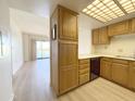 Kitchen with wood cabinets, modern appliances, and new wood floors at 10330 W Thunderbird Blvd # B313, Sun City, AZ 85351