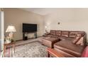Comfortable living room features a large leather couch and plush ottoman at 10860 W Buccaneer Dr, Sun City, AZ 85351