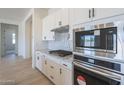 Close-up of kitchen with stainless steel appliances, granite countertops, and white cabinetry at 11002 N 164Th Dr, Surprise, AZ 85388