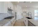 Bright, modern kitchen with white cabinets, granite countertops, and stainless steel appliances at 11002 N 164Th Dr, Surprise, AZ 85388